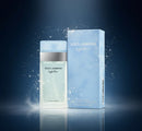 Perfume Dolce & Gabbana Light Blue com caixa, fundo azul, partículas brilhantes.