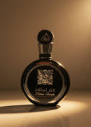 Frasco preto de perfume Fakhar Lattafa com detalhes dourados em fundo iluminado.