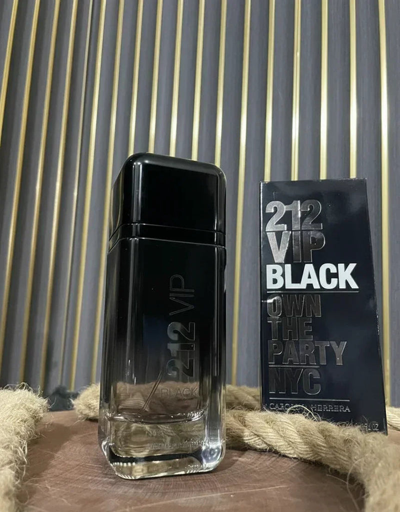 Perfume 212 VIP Black Carolina Herrera com caixa, sobre superfície de madeira e fundo listrado.
