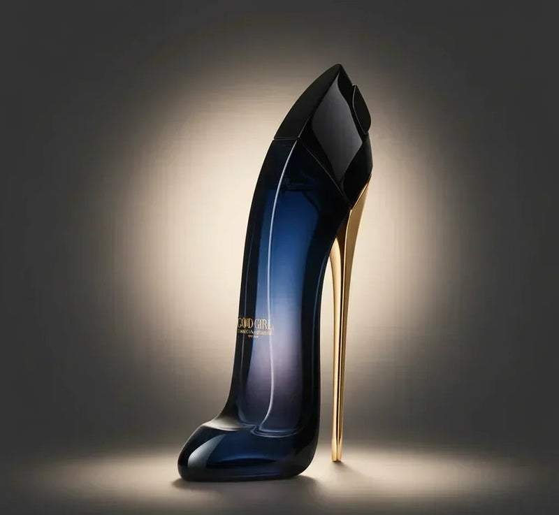 Perfume em formato de sapato salto alto preto e dourado sobre fundo escuro iluminado