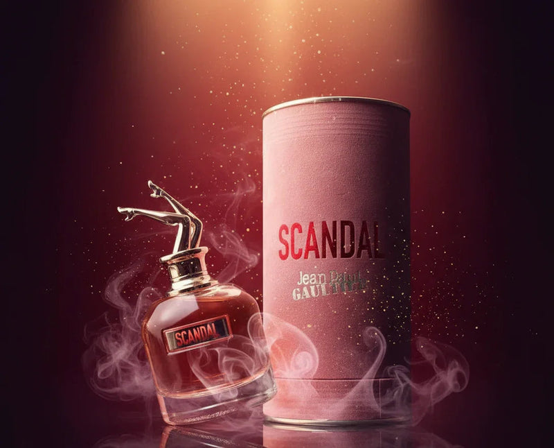 Perfume Scandal Jean Paul Gaultier com embalagem rosa e efeitos de fumaça, fundo escuro elegante.
