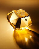 Frasco dourado de perfume Lady Million em fundo dourado iluminado, perfume de luxo.